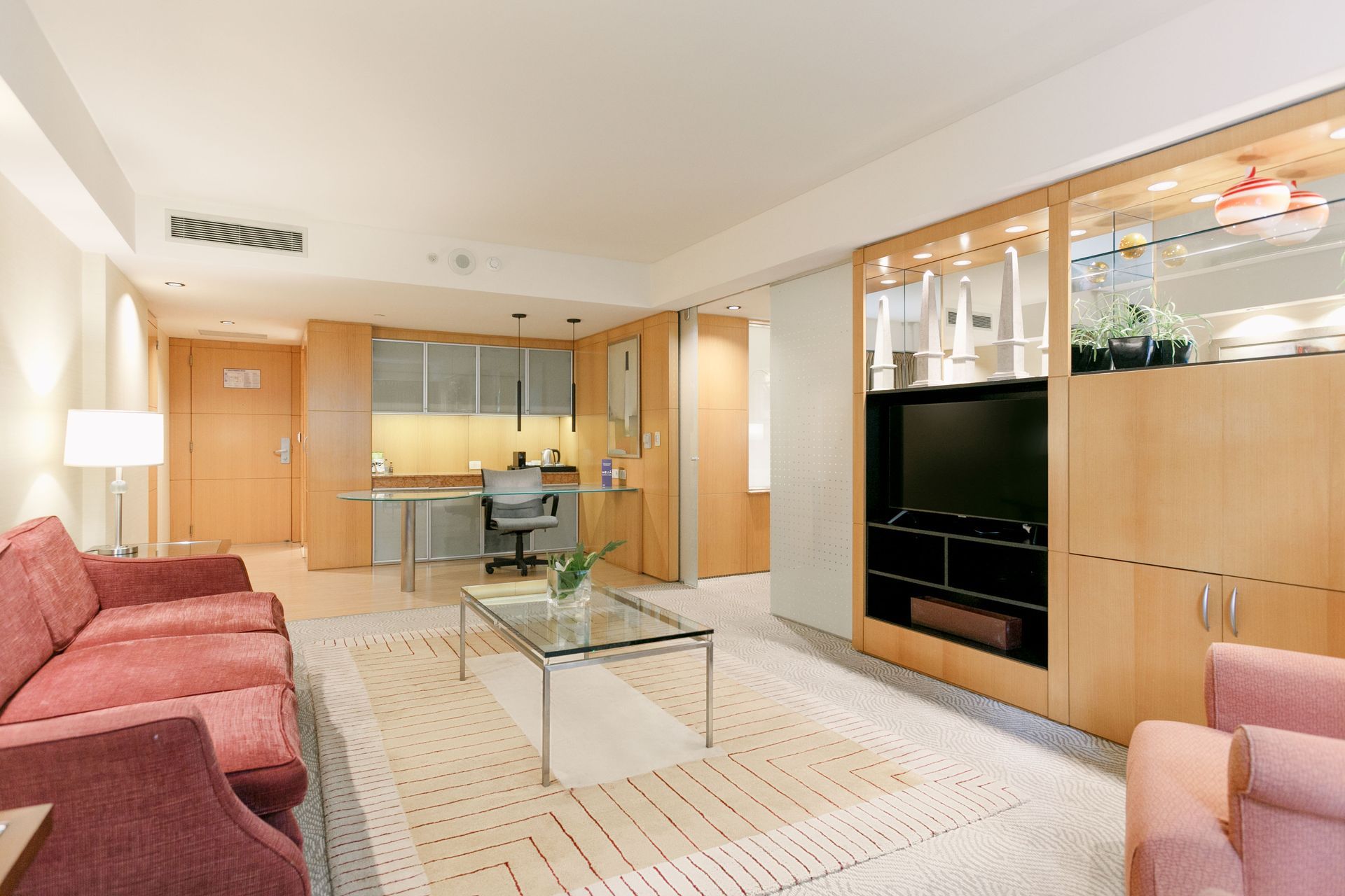 Una sala de estar con un sofá, un sillón y un televisor.