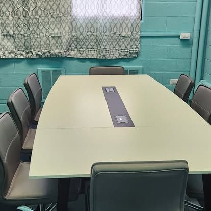 A conference room with a long table and chairs.
