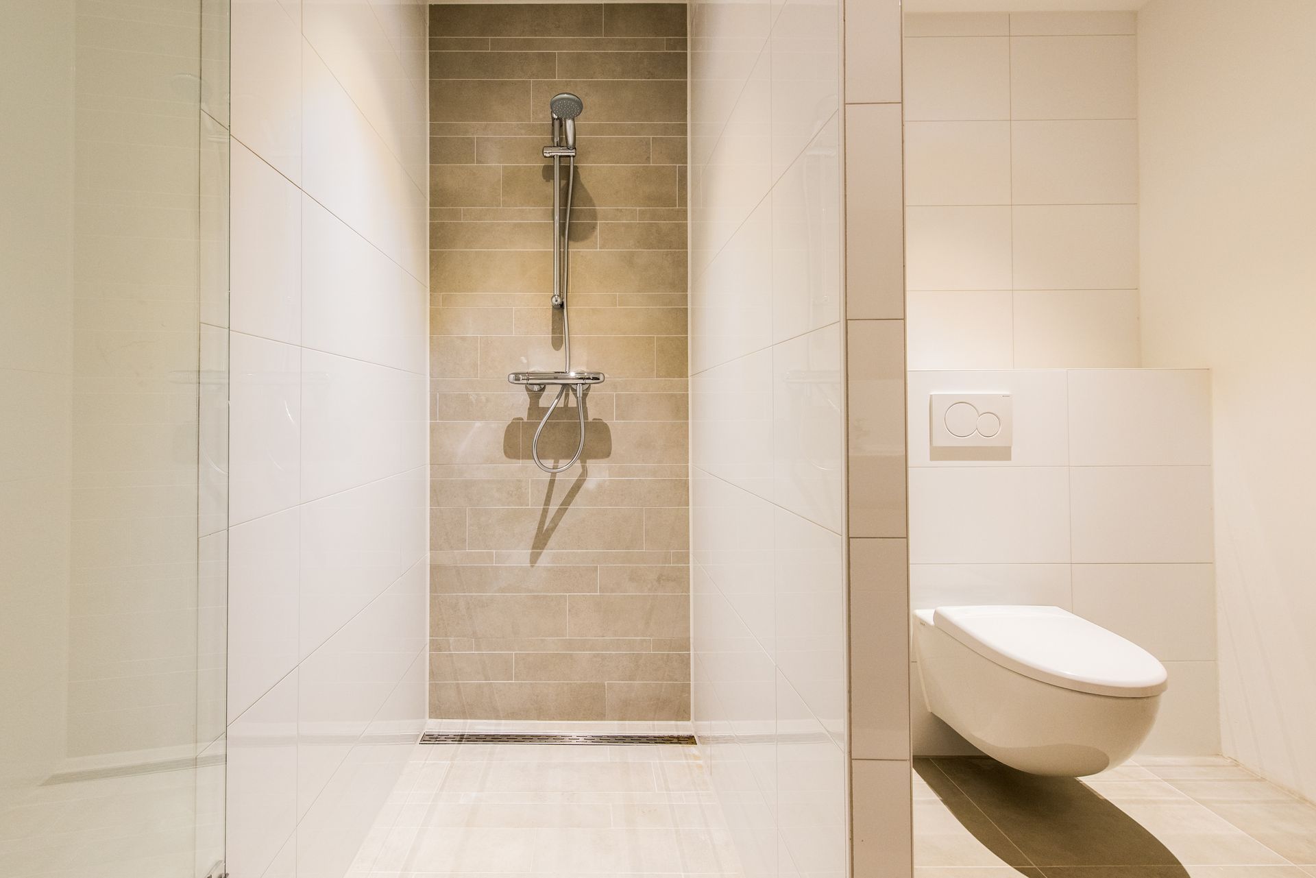 Moderne badkamer met inloopdouche en wandtoilet.