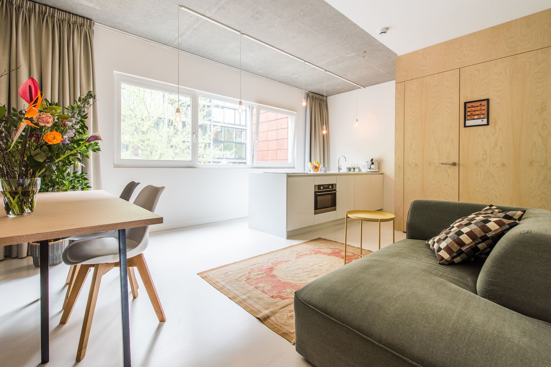 Modern appartementinterieur met keuken, eethoek en woonkamer.