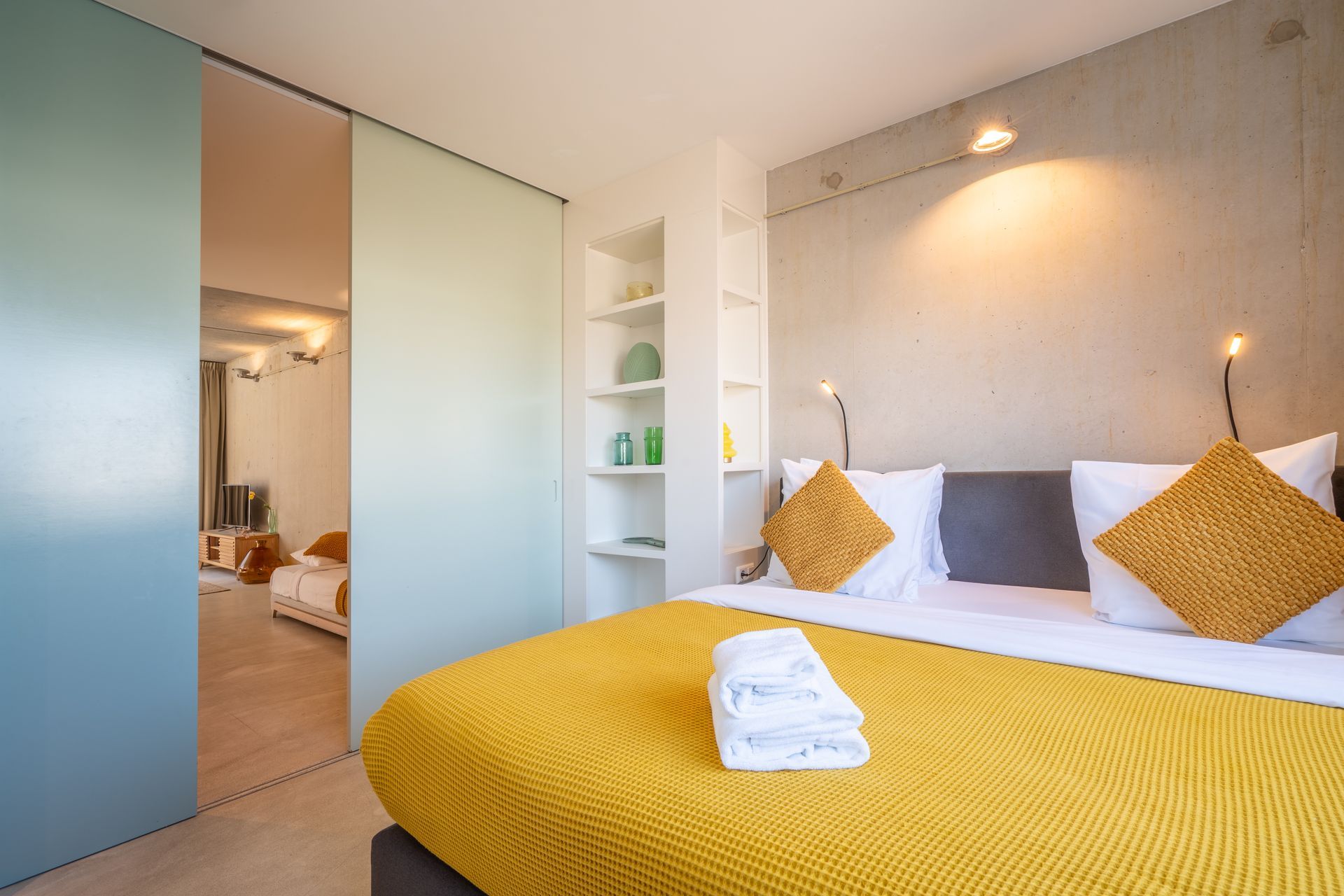 Eethoek met witte tafel, verschillende stoelen, hanglampen en een potplant.