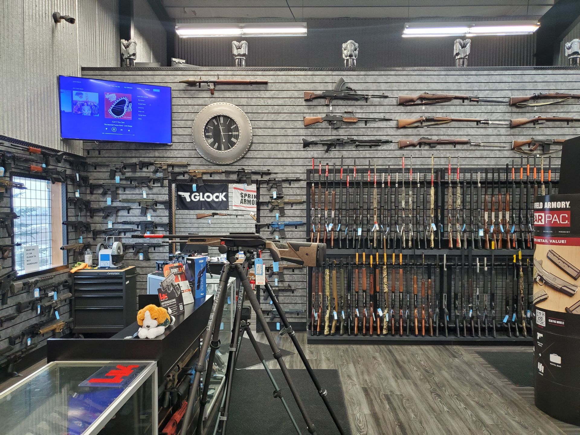 Gun store interior with various rifles and shotguns displayed on racks.