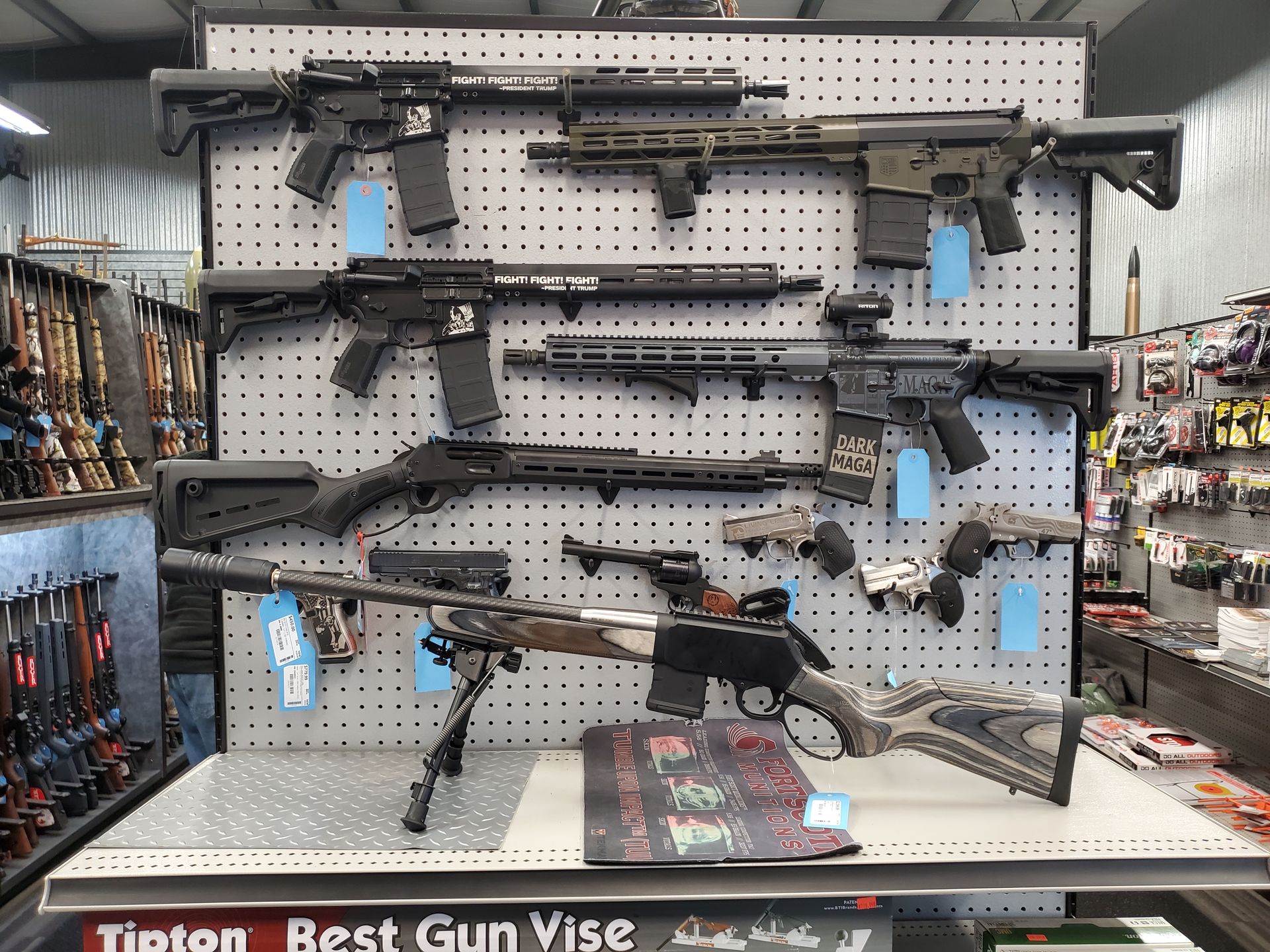 Guns mounted on a wall; a large sniper rifle is prominent.