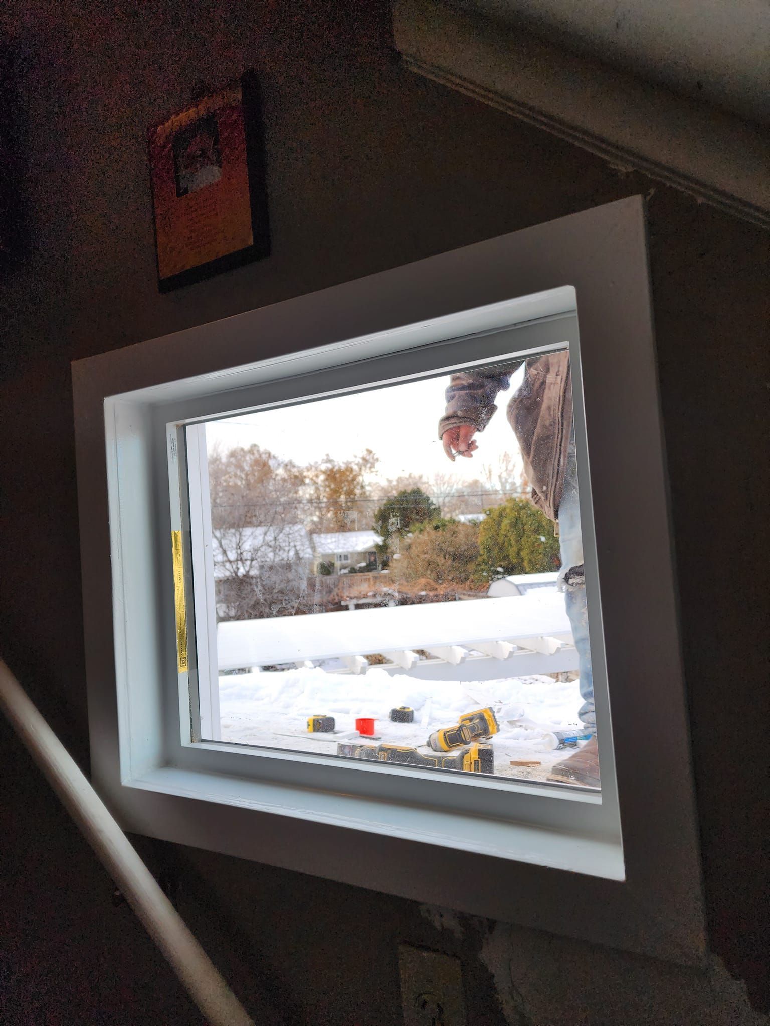 Window frame showing a snowy outdoor scene.