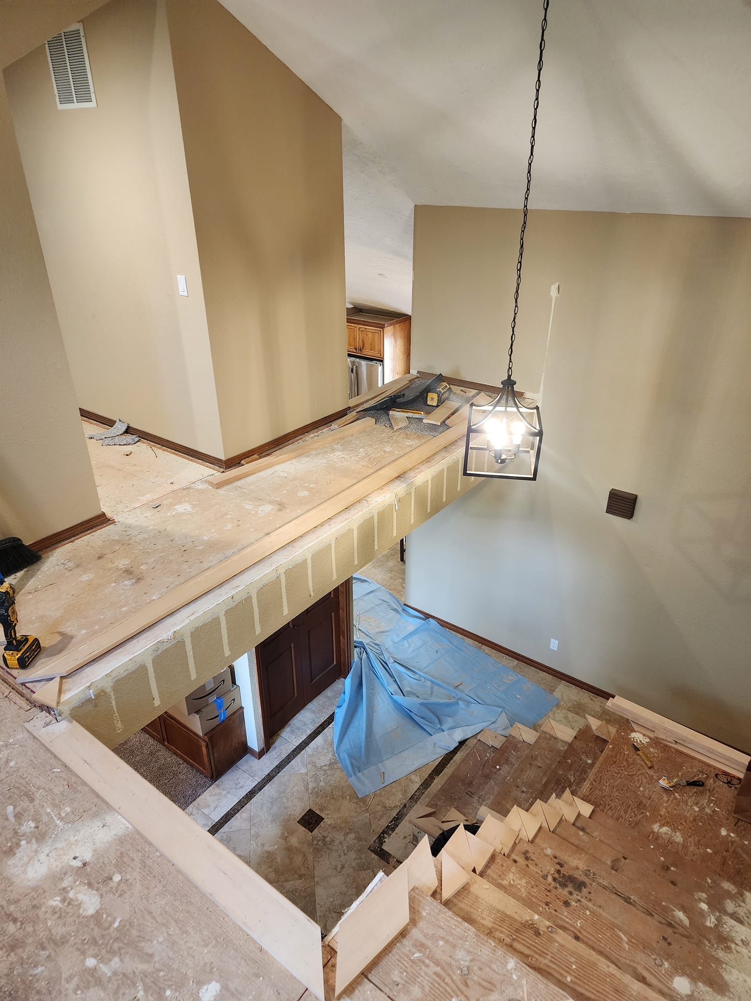 Interior view of a home renovation in progress, featuring exposed framing, flooring removal