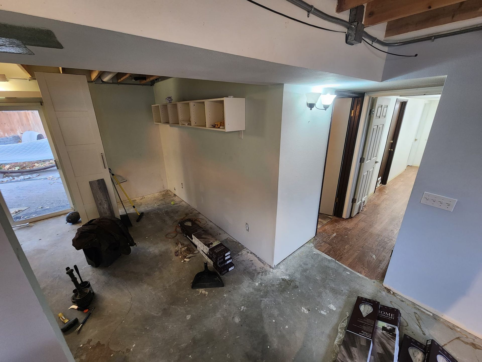 Renovation in progress: interior view of a room with exposed walls, debris, and open doorways.