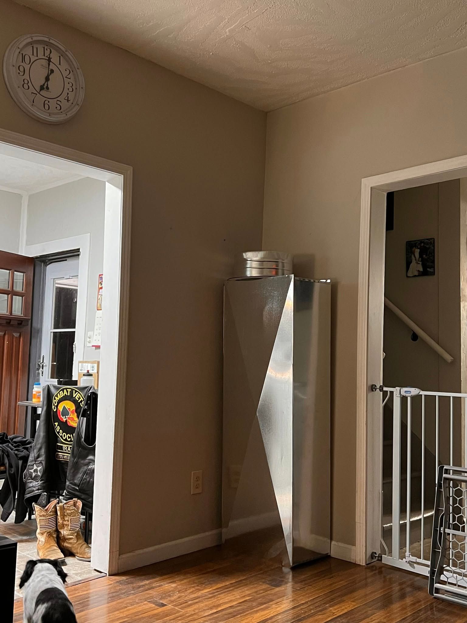 Interior view of a room with a refrigerator. A clock and doorway are visible.
