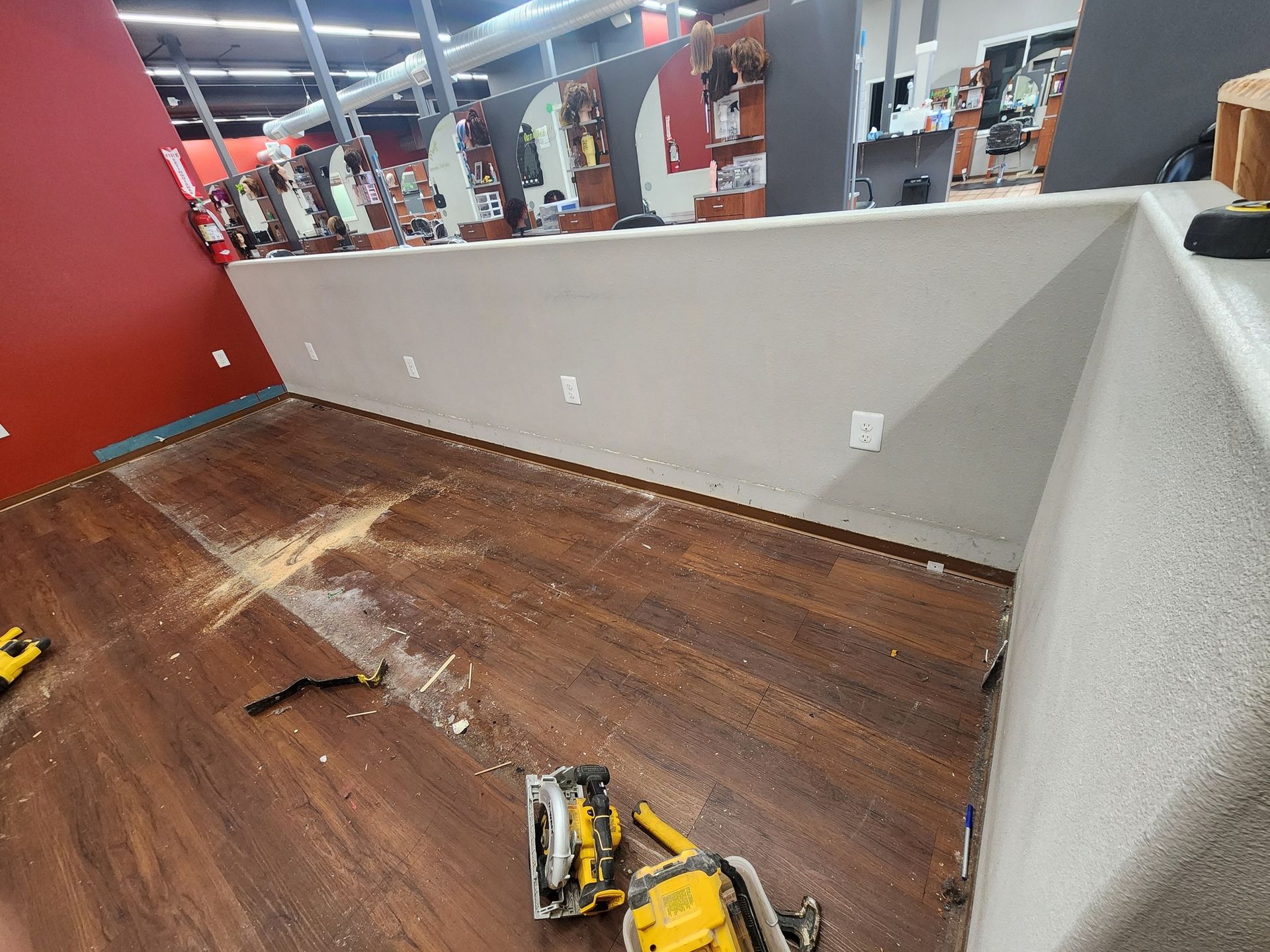 Construction: Wood flooring being installed in a commercial space, with tools and debris visible.