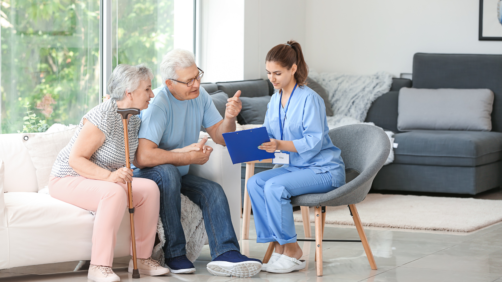 A nurse is holding the hand of an elderly woman.