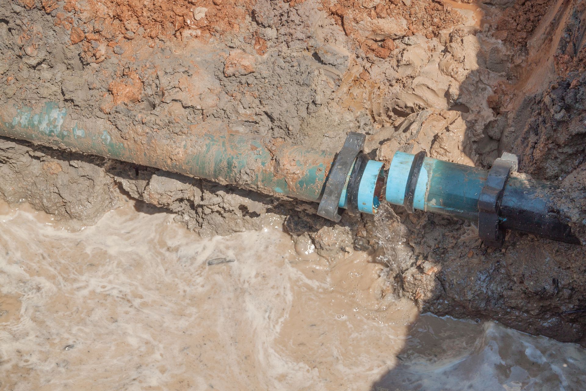 A broken water pipe is sitting in the dirt. — Hamden, CT — Drain Wizard
