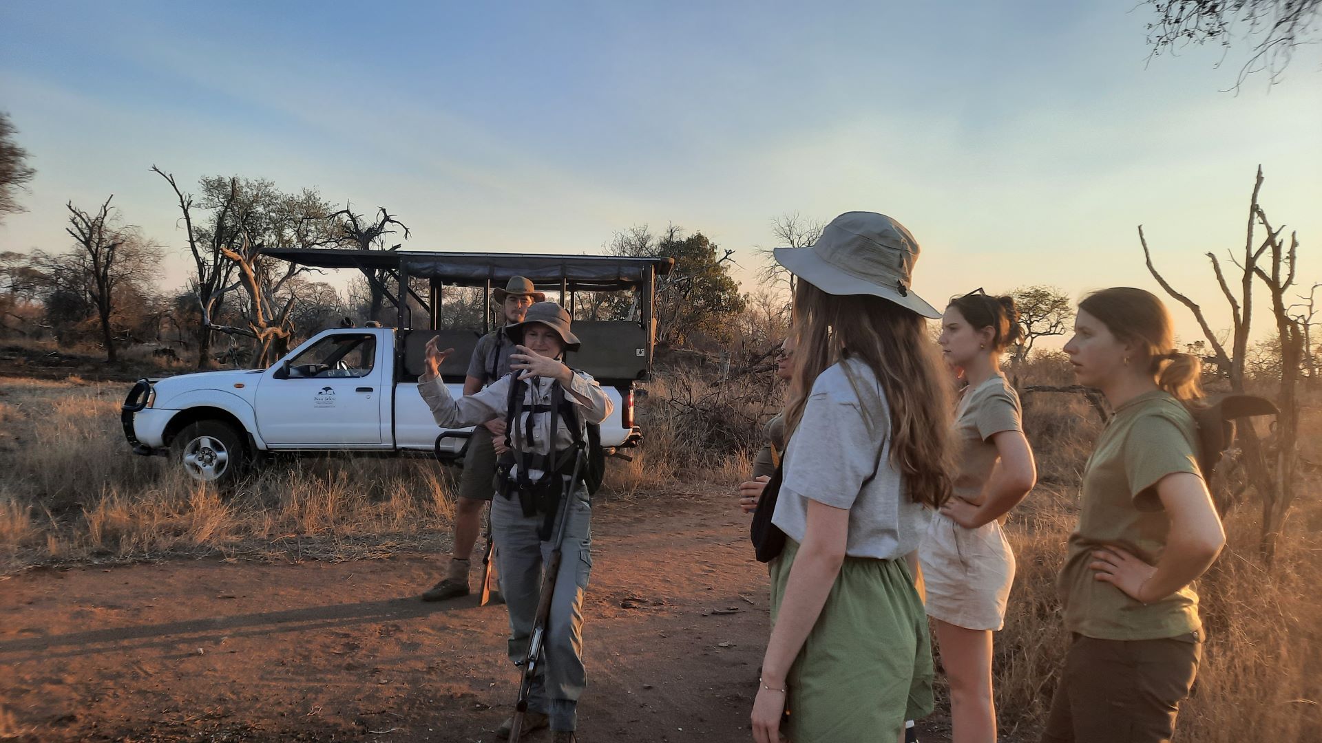 A group of people are standing in front of a white truck.