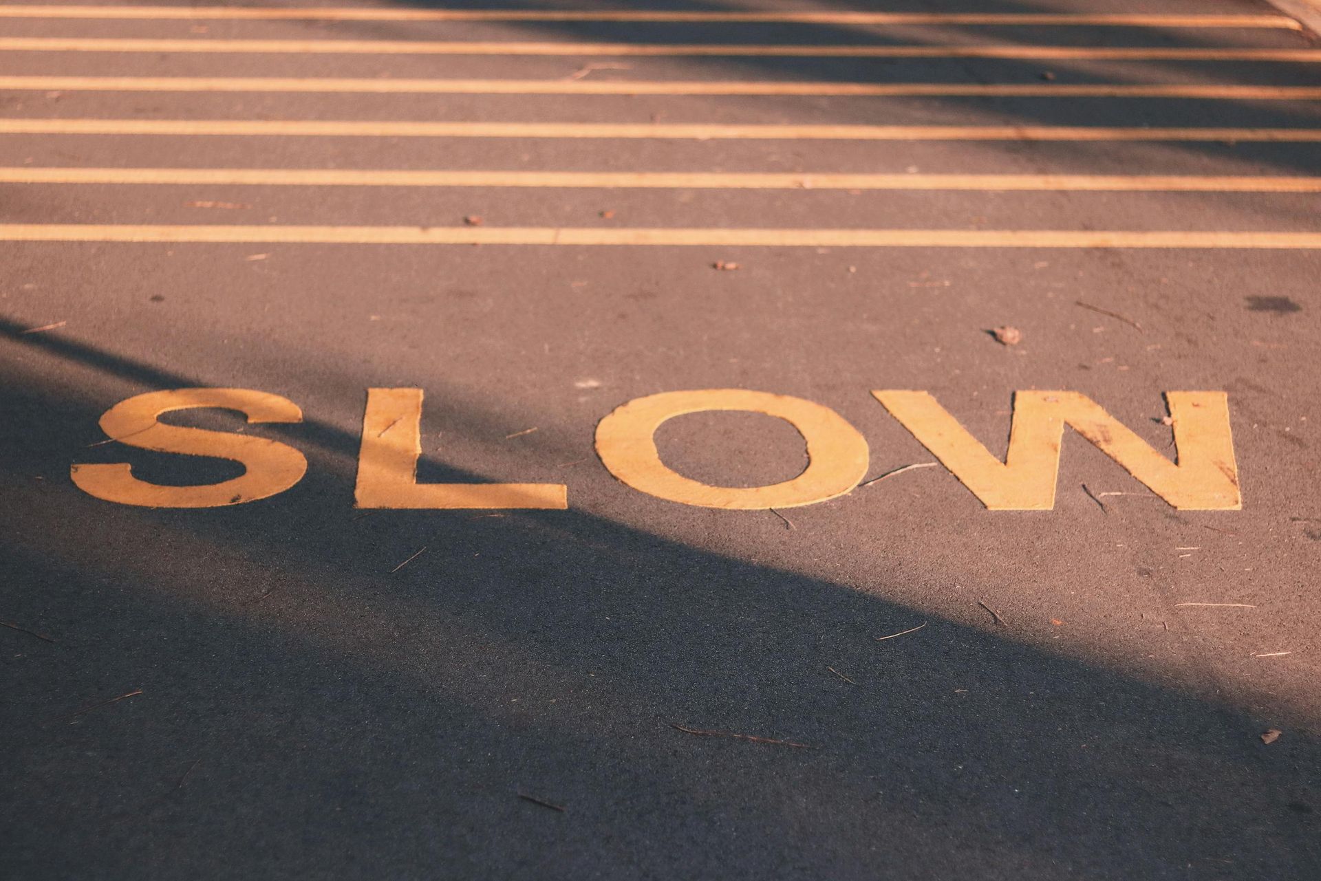 The word slow is painted on the side of the road.