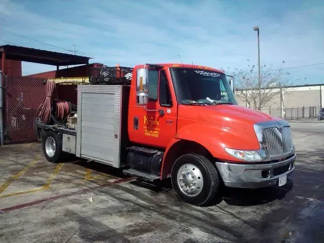 Red and silver service truck parked outdoors.