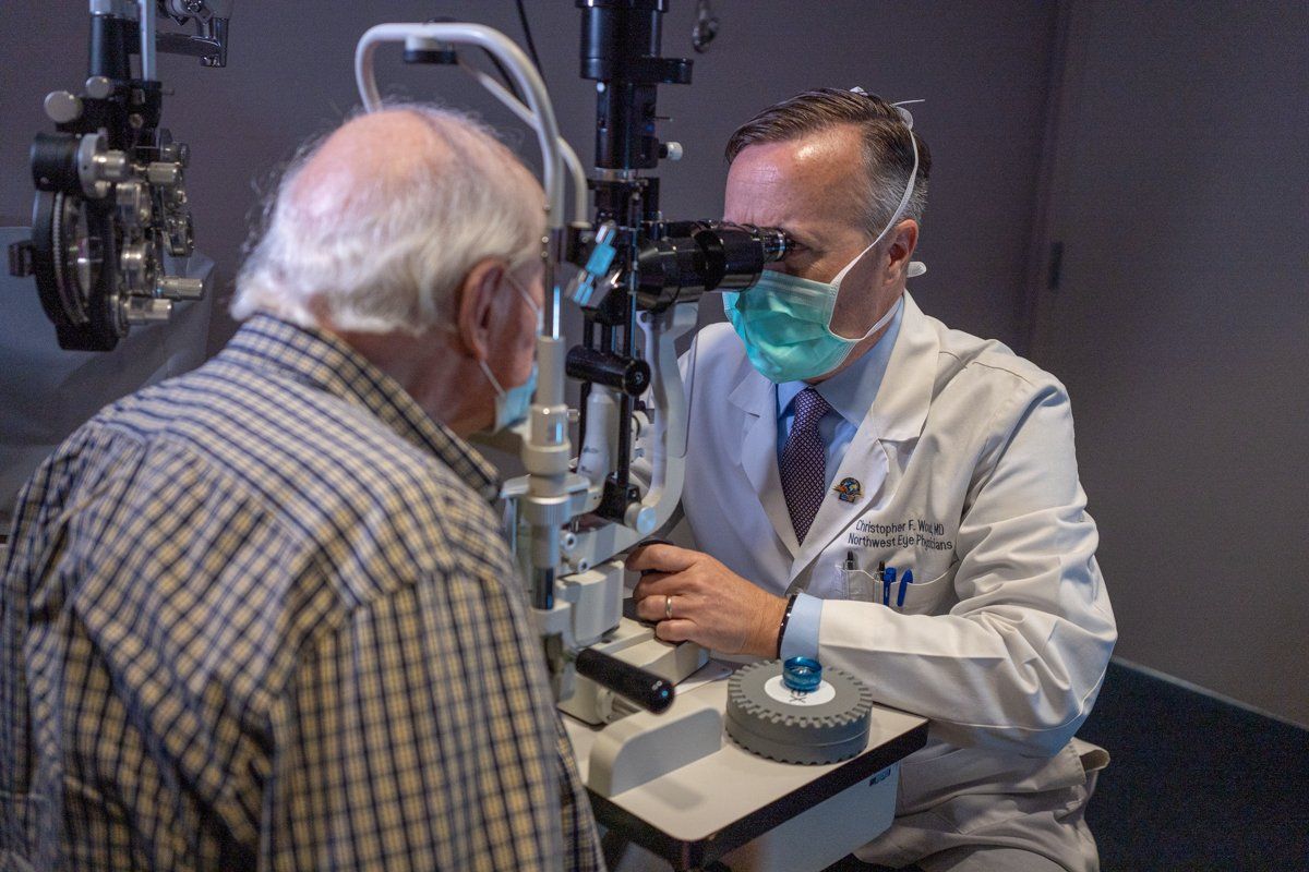 An older man is getting his eyes examined by an ophthalmologist.