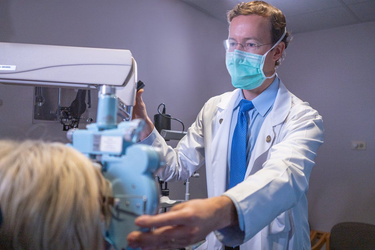 A doctor wearing a mask is giving a patient an x-ray.