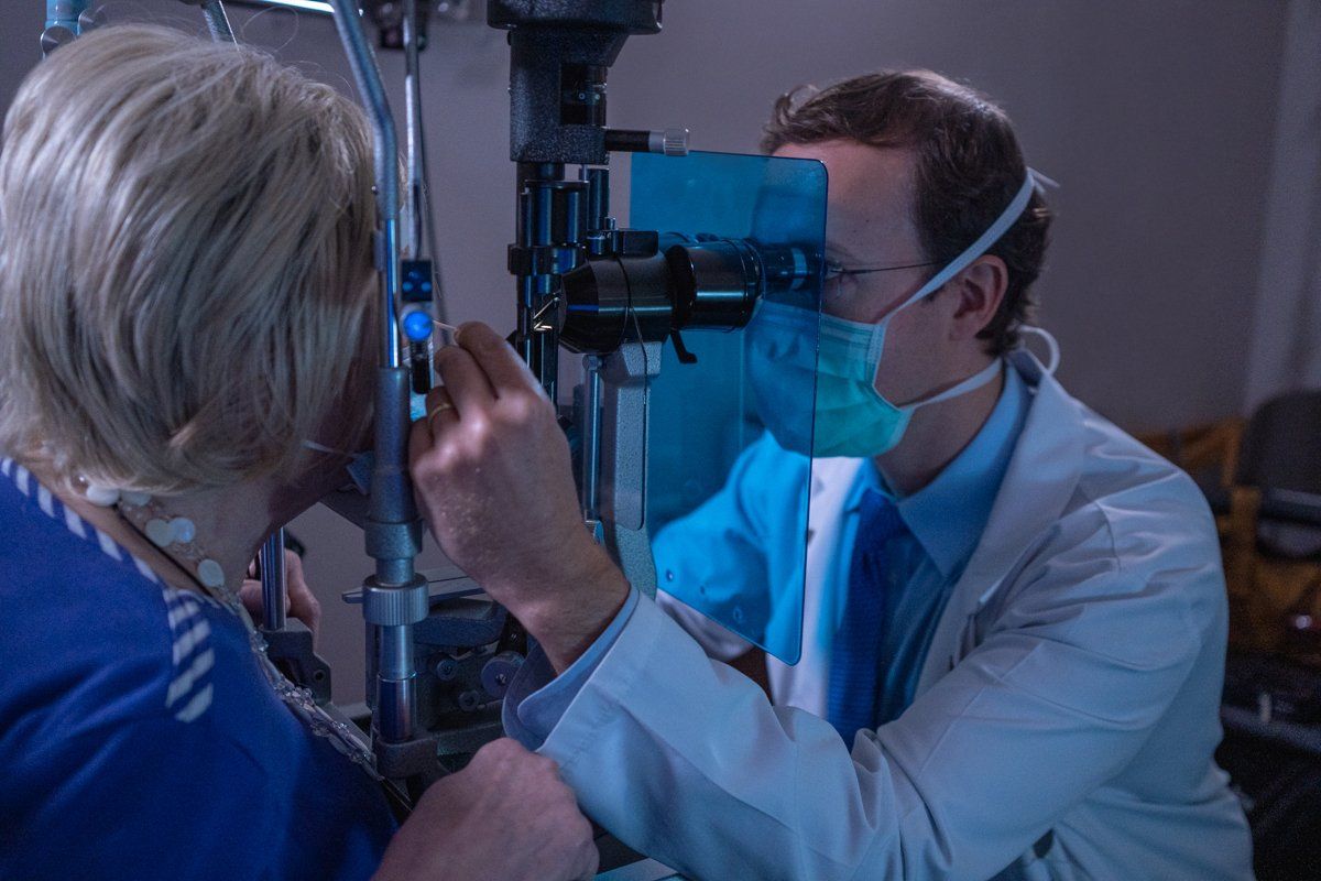 A doctor is examining a patient 's eye with a machine.