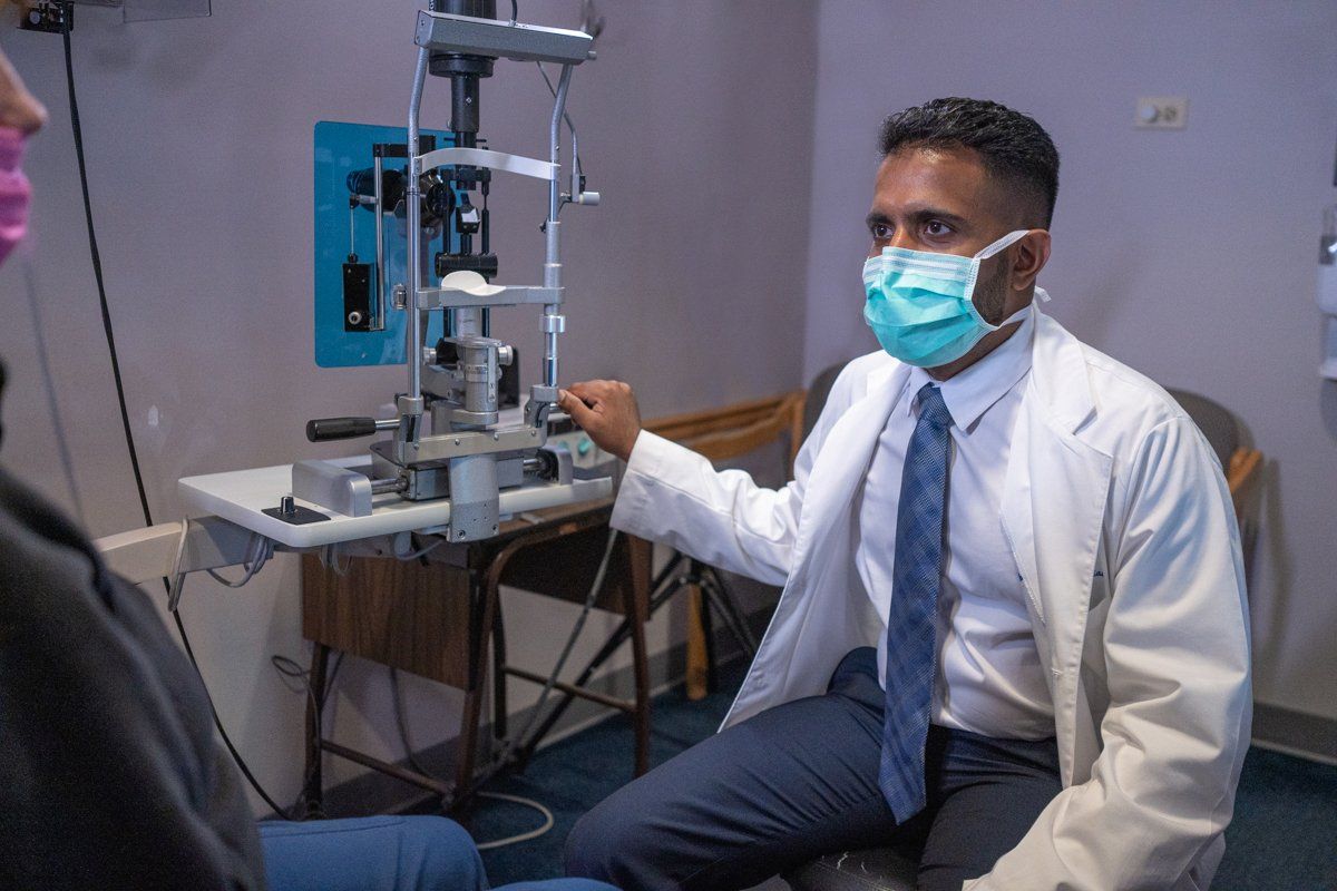A doctor wearing a mask is talking to a patient.