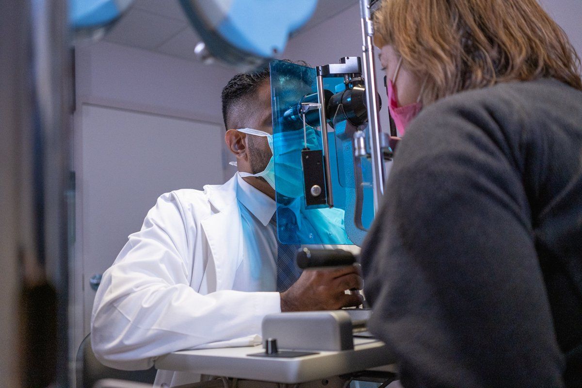 A doctor is examining a patient 's eye in an operating room.