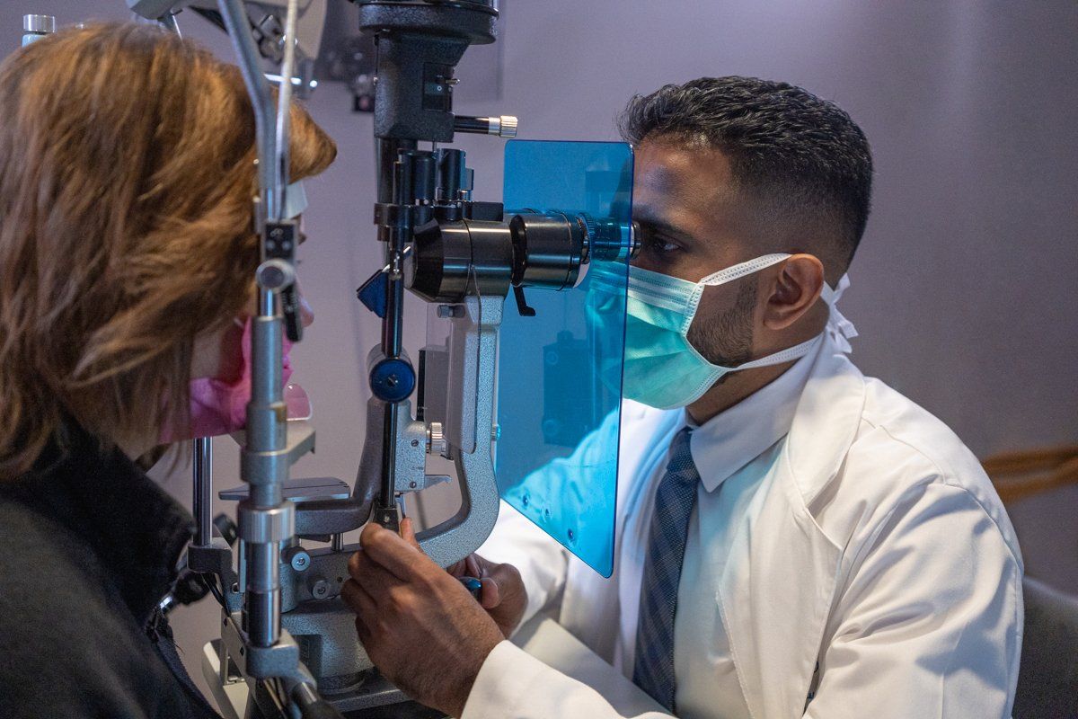 A doctor is examining a patient 's eye with a machine.