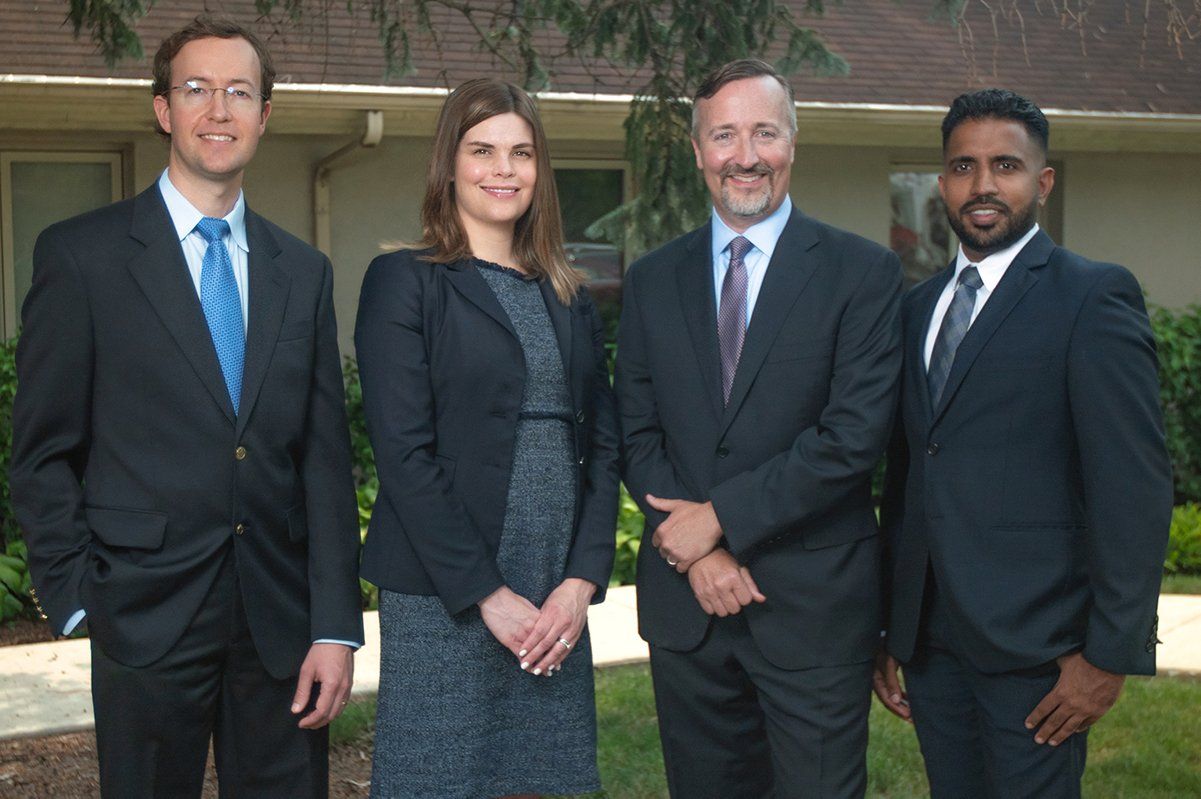 A group of people in suits and ties are posing for a picture.