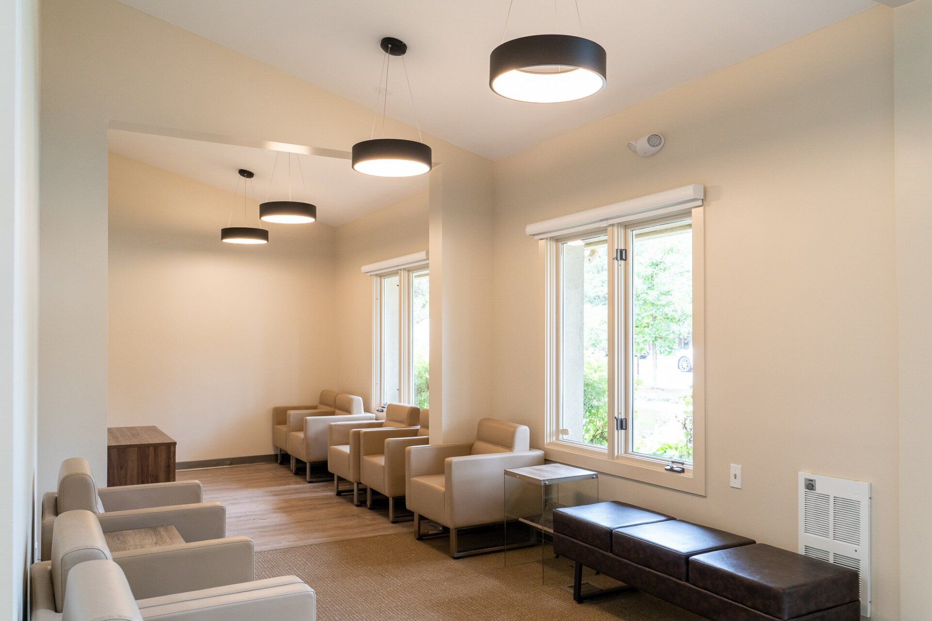 A waiting room with a row of chairs and a bench.