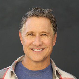 A man in a plaid shirt is smiling for the camera.