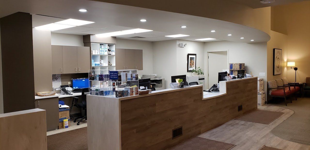 A hospital reception area with a long counter and a waiting room.