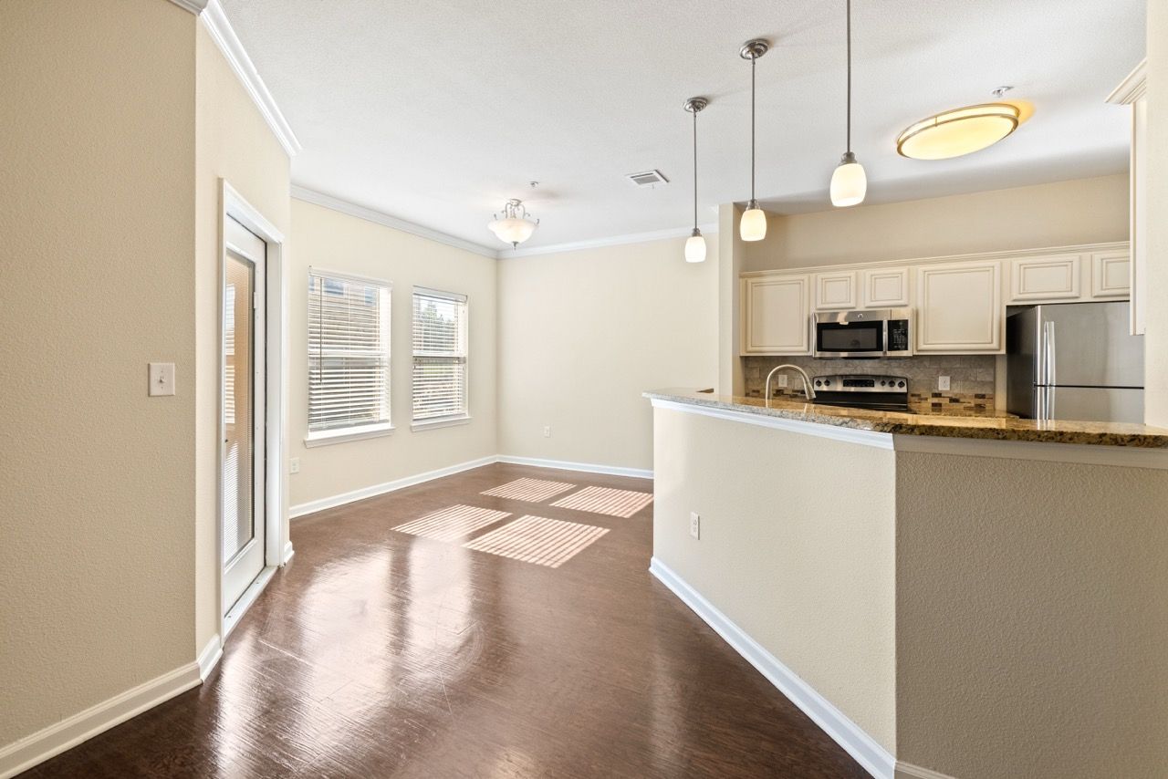 Open-concept kitchen with granite counter, bar seating, and stainless appliances.