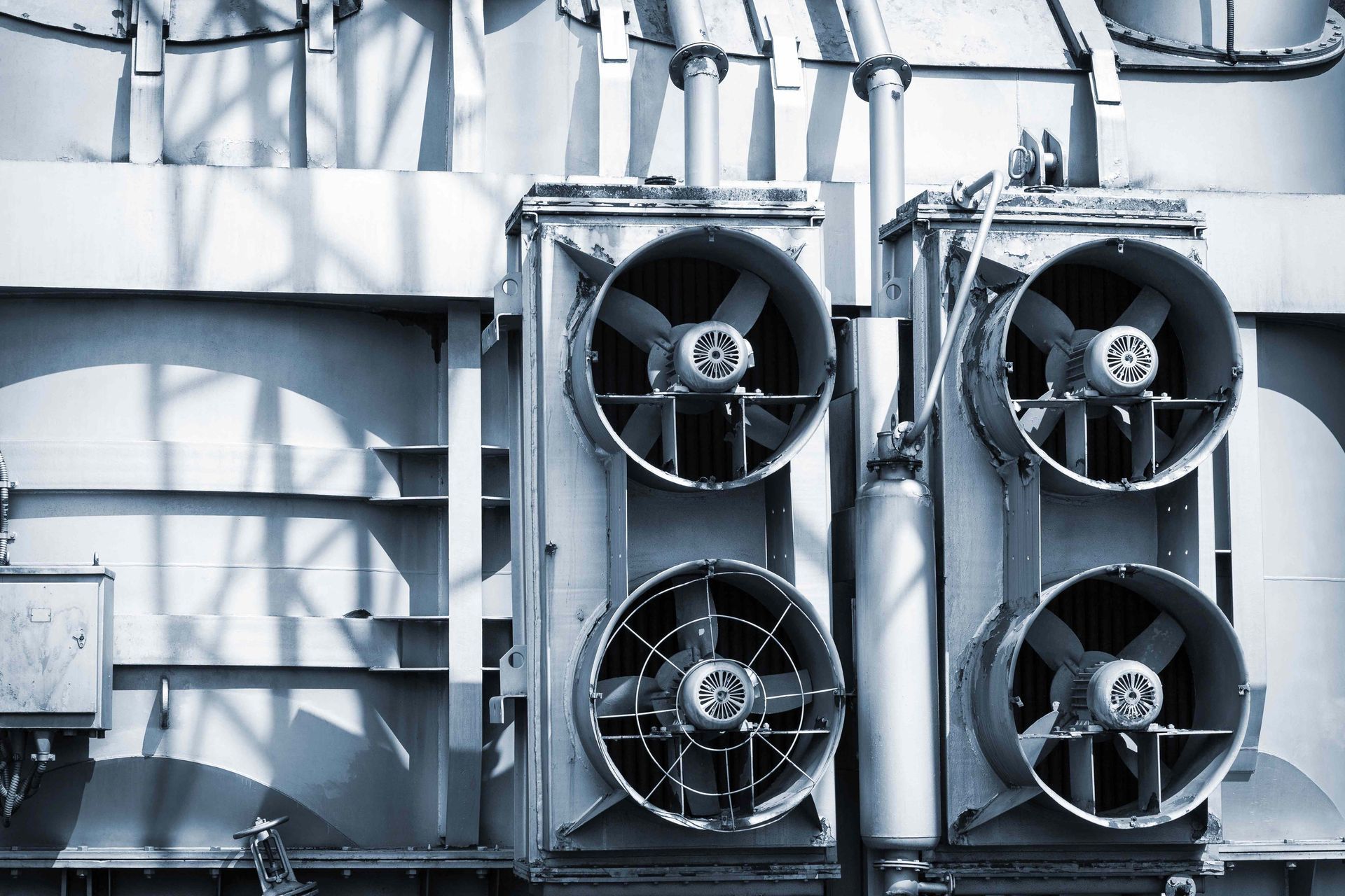 Cuatro ventiladores industriales de gran tamaño montados sobre una estructura metálica de color gris.