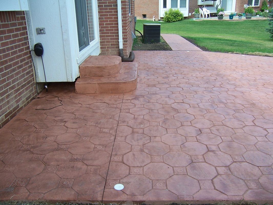 A brick house with a concrete walkway leading to it