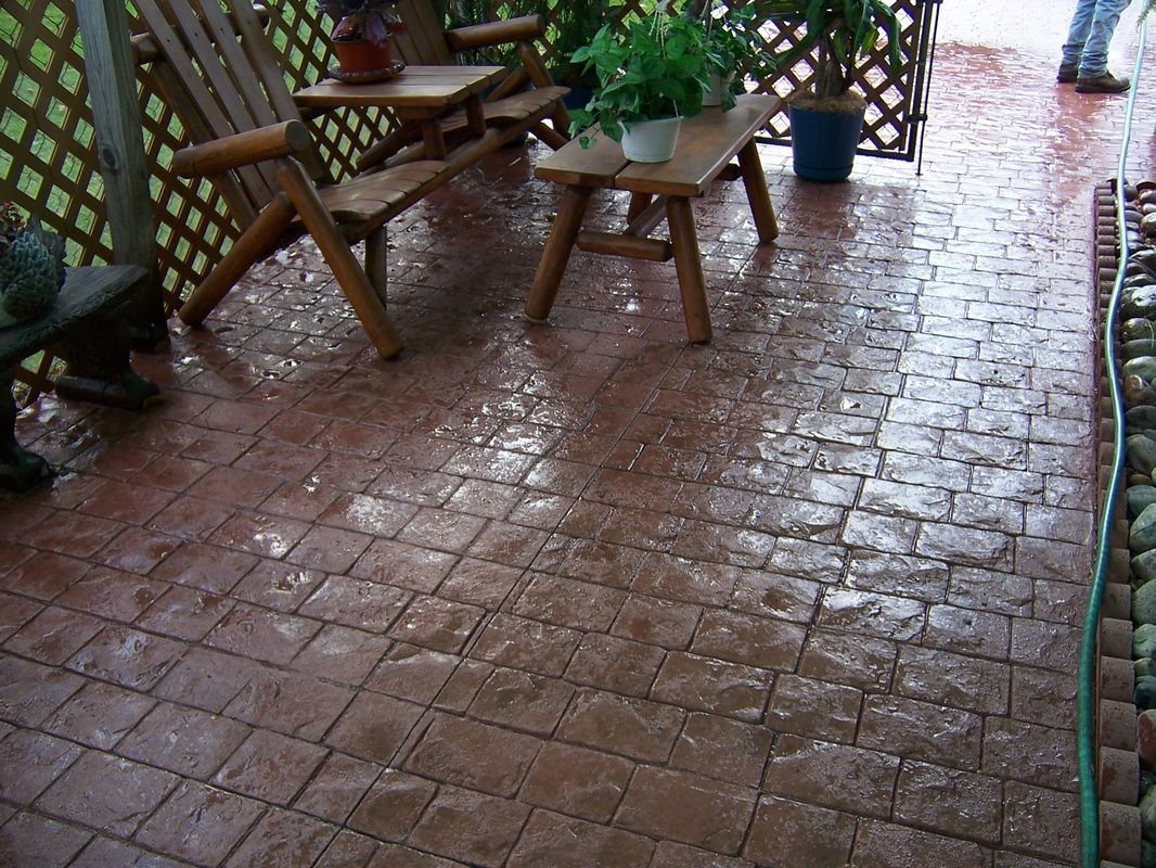 A patio with chairs and a table in the rain