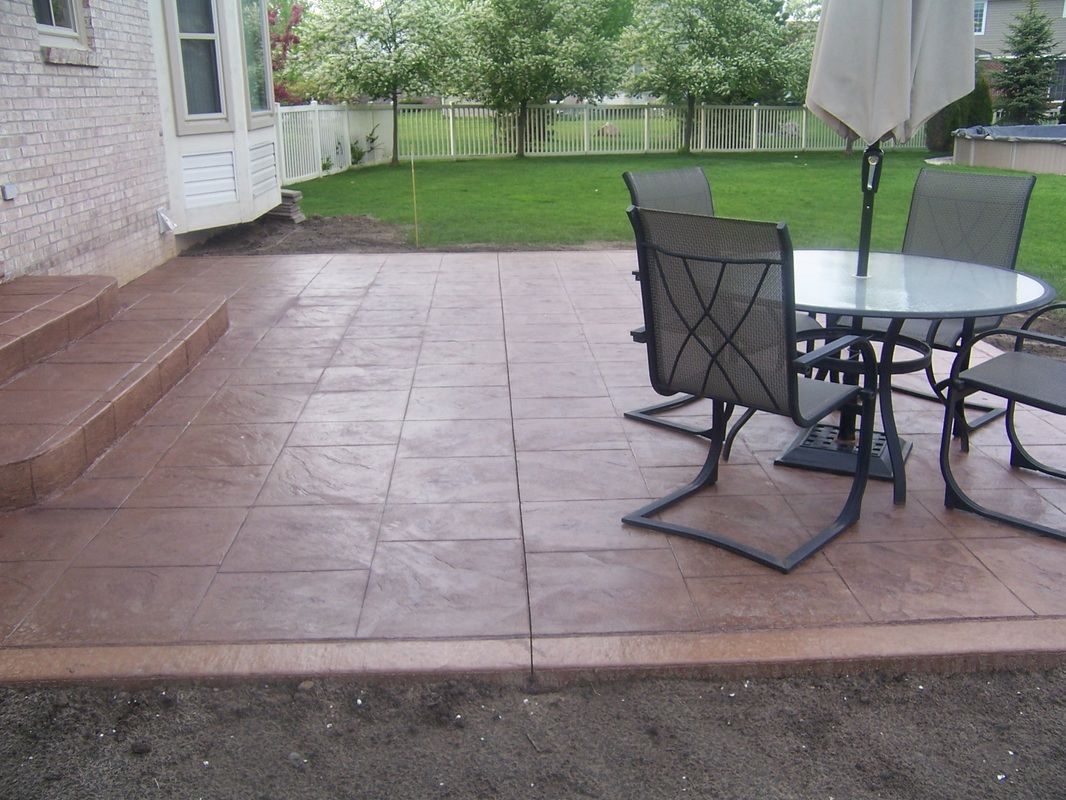 A patio with a table and chairs and an umbrella