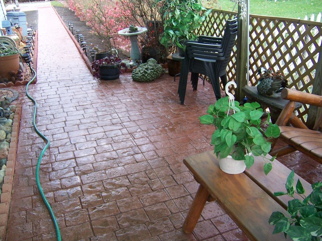 A patio with a picnic table and chairs and a hose