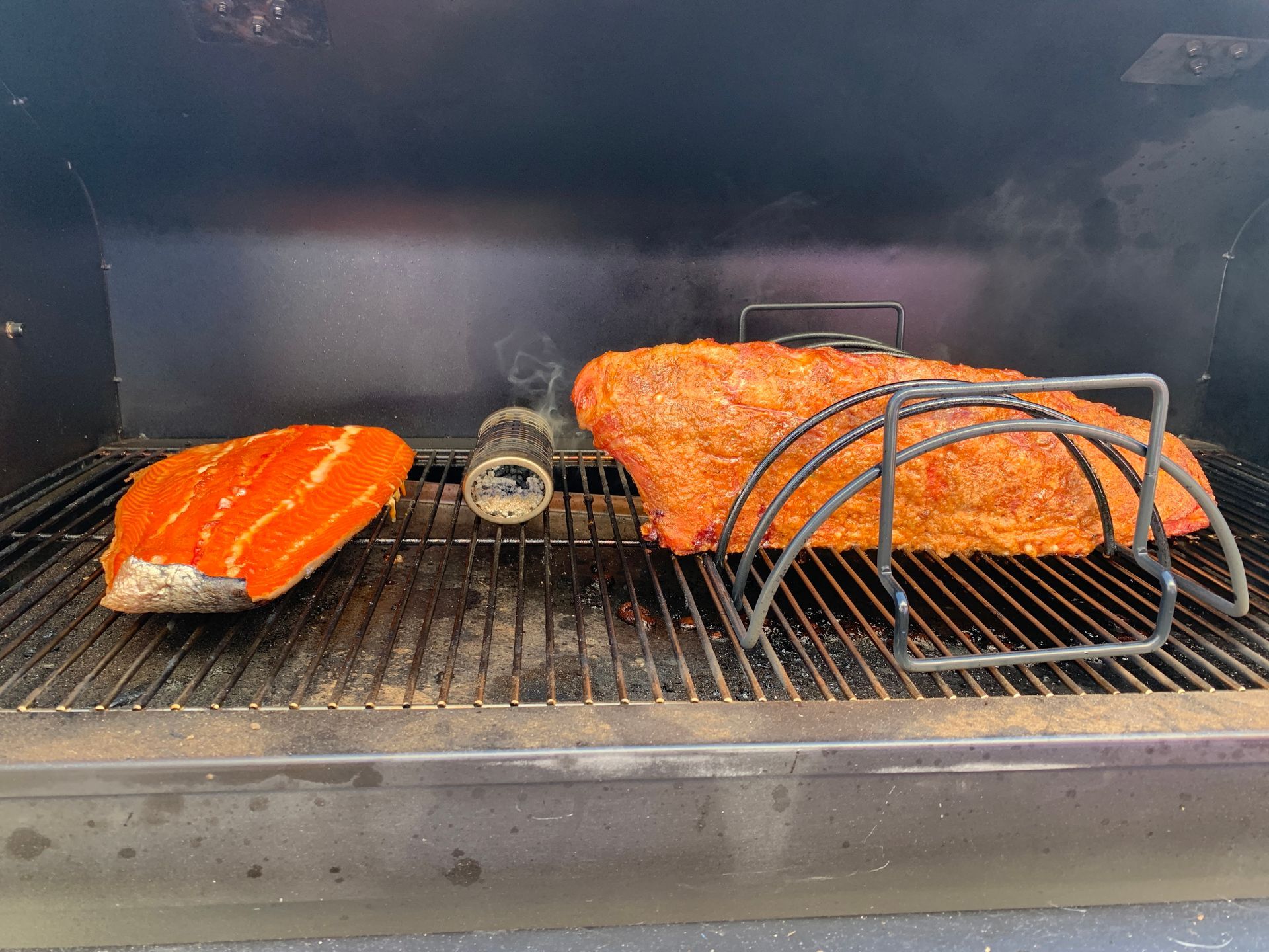 Two pieces of meat are cooking on a grill.