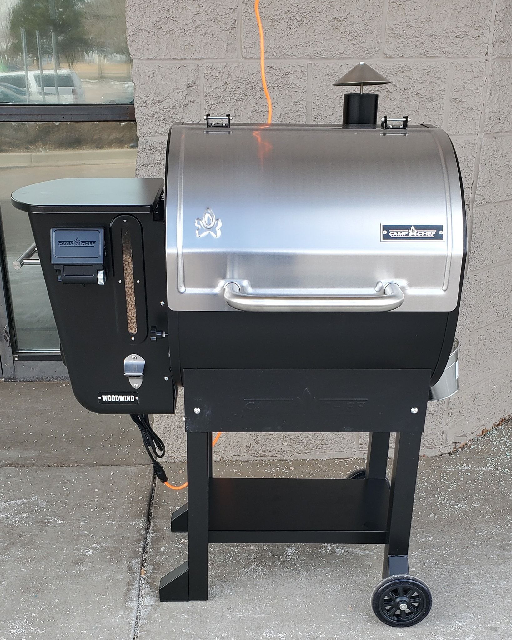 A stainless steel grill is sitting in front of a building