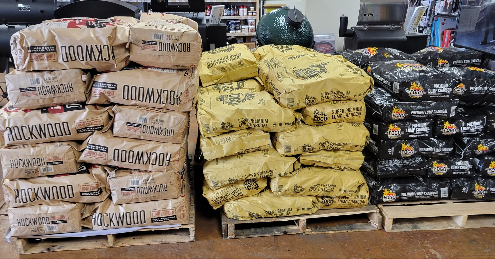 A bunch of bags of charcoal are stacked on top of each other on wooden pallets.