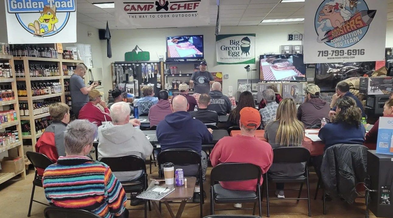 A group of people are sitting at tables in a room watching a presentation.