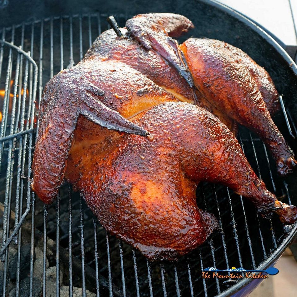A smoked chicken is cooking on a grill with a picture of it on the bottom