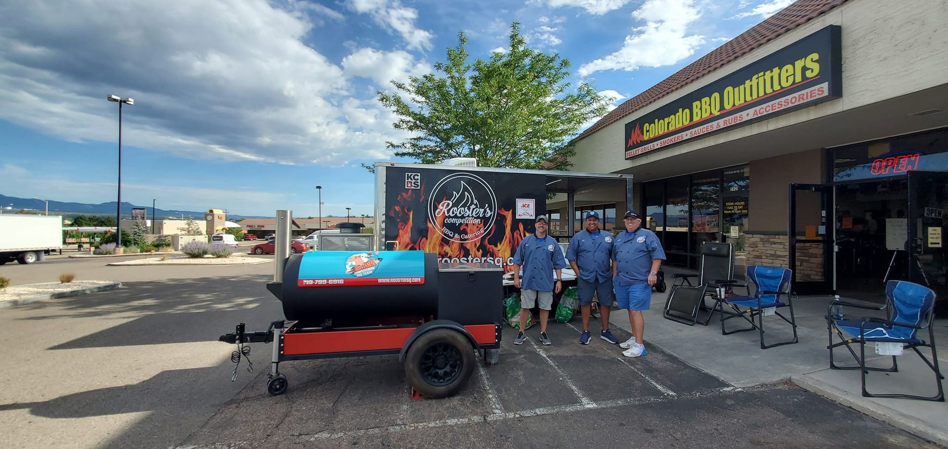 A group of people are standing in front of a trailer in a parking lot.