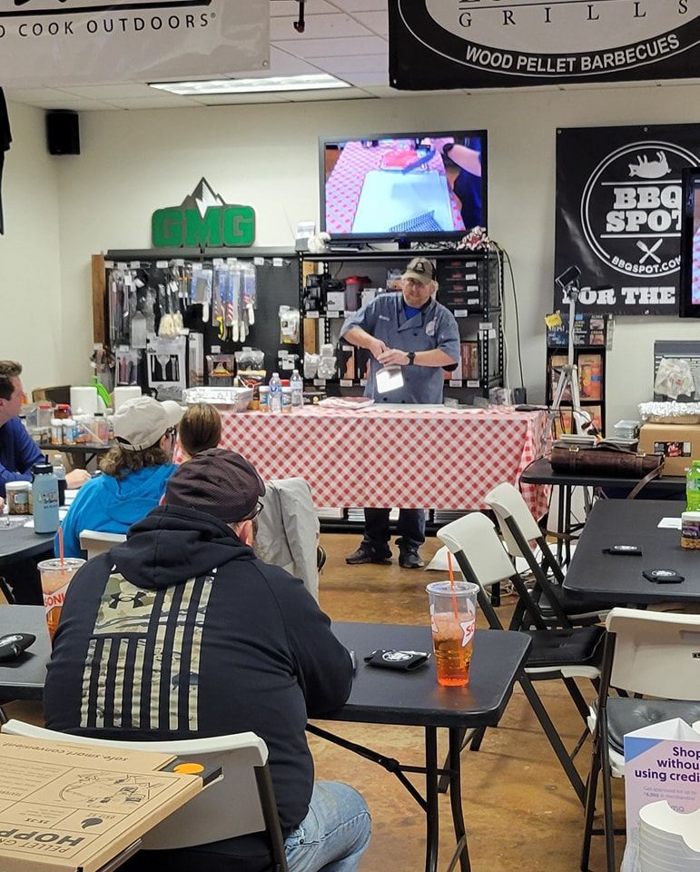 A group of people are sitting at tables in front of a man giving a presentation.