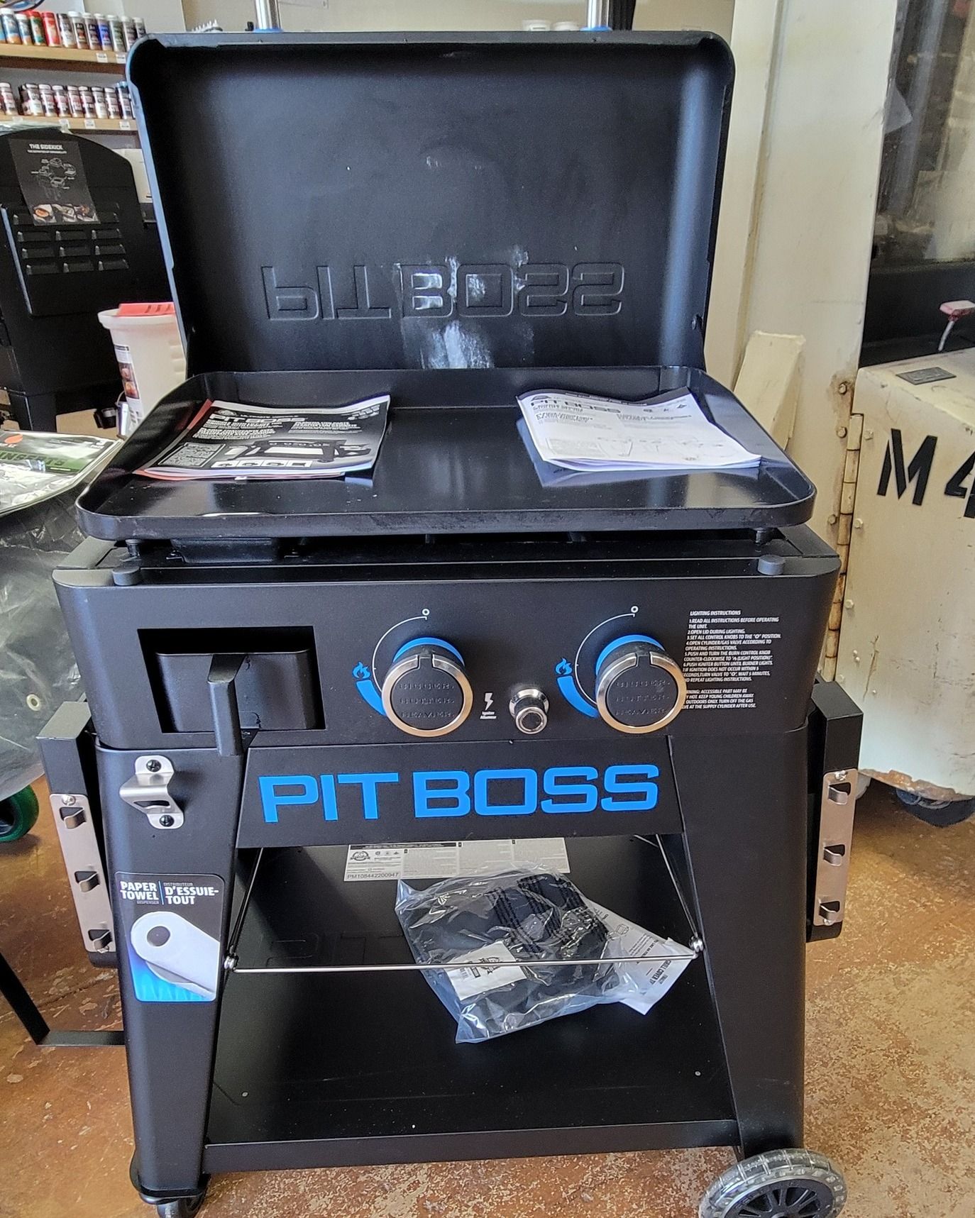 A pit boss grill is sitting on the floor in a room.