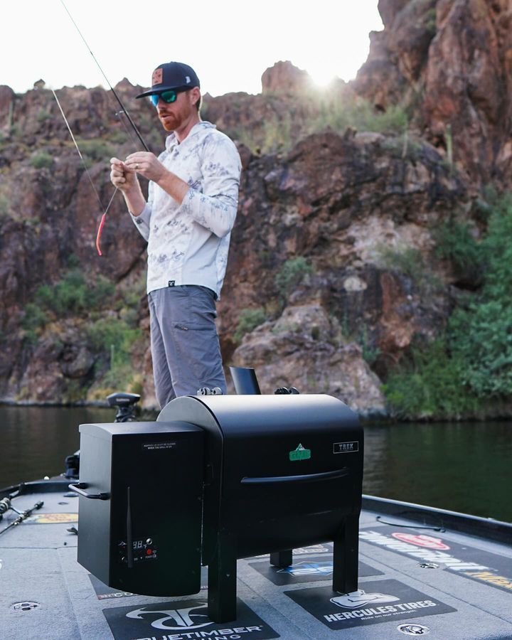 A man is standing on a boat holding a fishing rod.