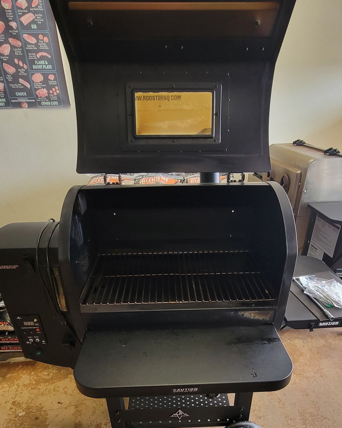 A black grill with the lid open is sitting on a table