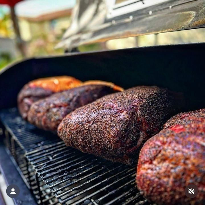 Three pieces of meat are cooking on a grill