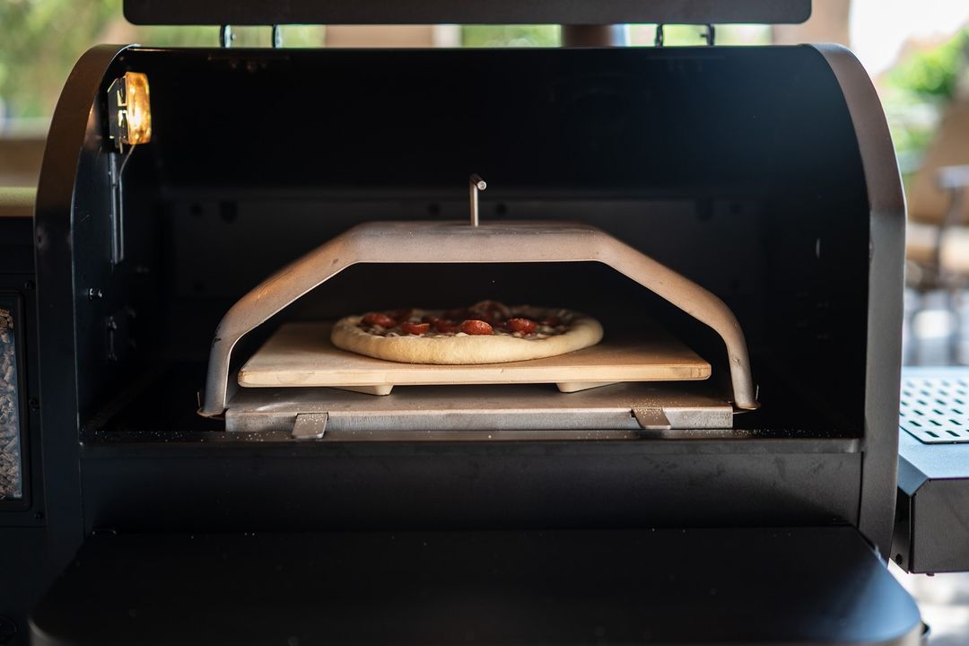 A pizza is being cooked in a pizza oven.