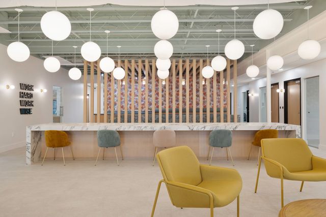 A living room with yellow chairs and a marble counter.
