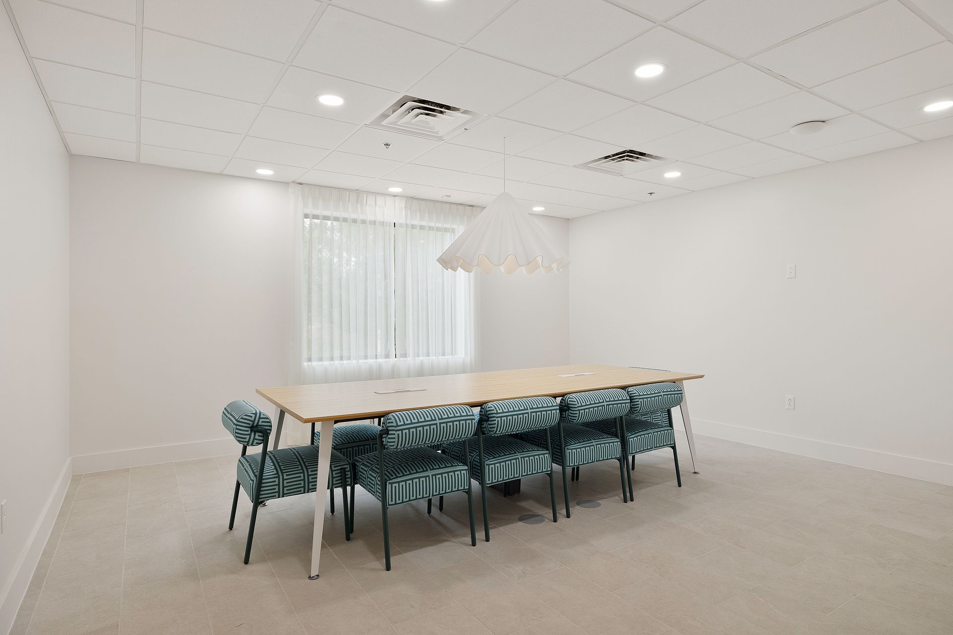 A conference room with a long table and chairs.