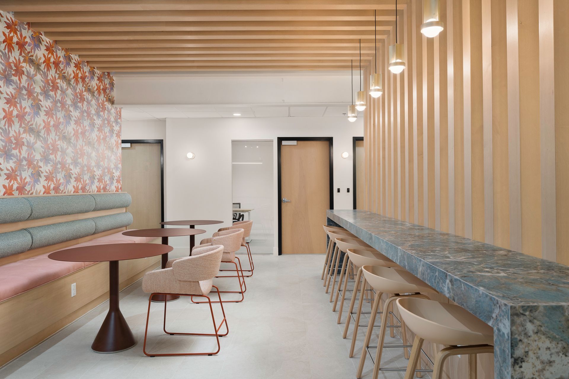 A room with tables and chairs and a long counter.
