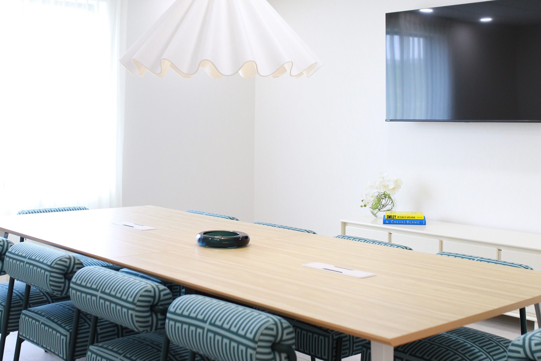 A conference room with a long table and chairs.
