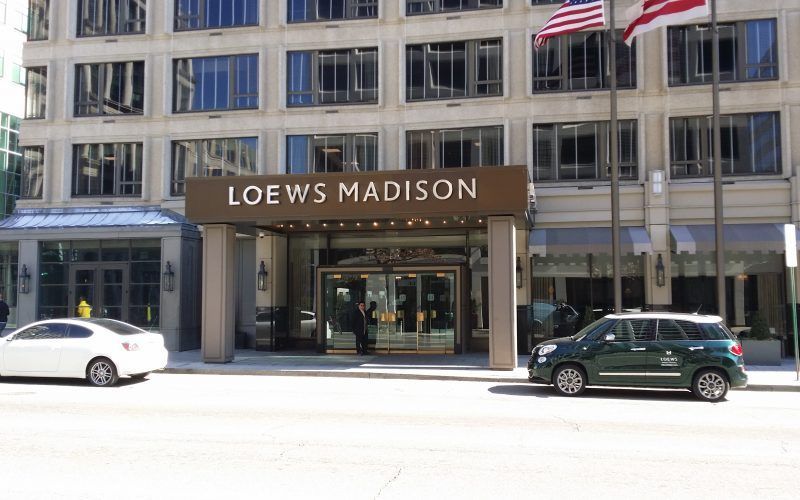 A loews madison hotel with cars parked in front of it